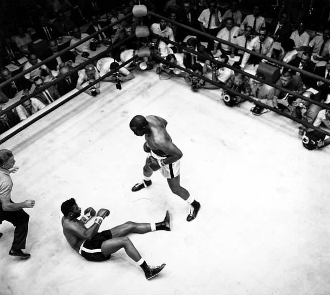 Floyd Patterson is on the ground after world heavyweight champion Sonny Liston staggers with a right then connects with a left for the knock out in Las Vegas, Nev. on July 22, 1963. This is the third in a three-picture sequence of the final knockout of Patterson in this match. (AP Photo)